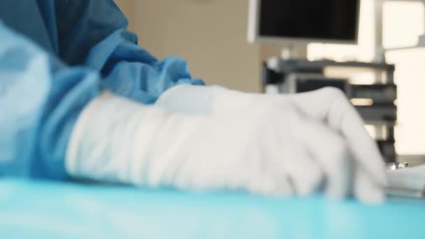 Surgery tools in operating room. Multiple surgery tools on a plate in operating room. Doctors and nurse picking it up. A table of medical tools are placed upon a table in preparation for surgery — Stock Video