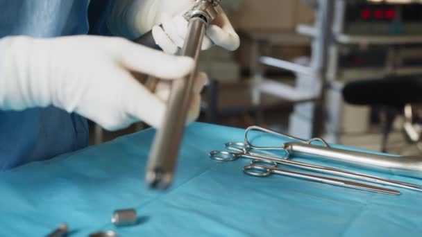 Masada cerrahi tıbbi aletler var. Ameliyat hemşiresi ameliyat için tıbbi gereçleri hazırlıyor. Tıbbi konsept. Laparoskopi için elle tutulur sterilize cerrahi aletler. — Stok video