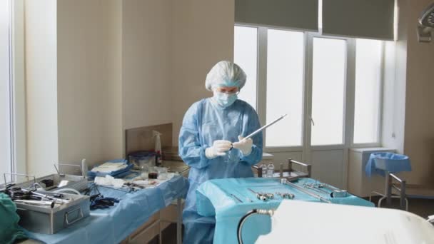Πορτρέτο της γυναίκας ιατρός με προστατευτική μάσκα προετοιμασία για τη χειρουργική επέμβαση. Χειρουργικό όργανο. Προετοιμασία για χειρουργείο. Κλείστε λαπαροσκοπικά όργανα. Χρήση λαπαροσκοπικού εξοπλισμού. — Αρχείο Βίντεο