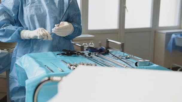 Una mesa de herramientas médicas se colocan sobre una mesa en preparación para la cirugía robótica. Preparación para laparoscopia. Preparación para la cirugía. Cierra los instrumentos laparoscópicos. Equipos laparoscópicos — Vídeos de Stock