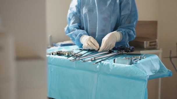 외과 기구. 수술 준비요. 복강경으로 봉합하고. 복강경 장비를 사용 한다. 수술 준비를 하는 보호용 마스크를 쓰고 있는 여성 의료 종사자의 모습 — 비디오