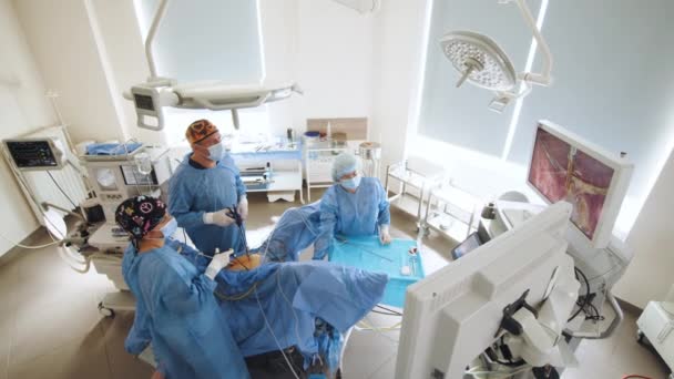 Cerrahlar hastane ameliyathanesinde ameliyat öncesi ameliyat, erkek cerrah ameliyat, ameliyat önlüğü, ameliyathane, cerrahi laparoskopi aletleriyle çalışma. Jinekoloji. — Stok video