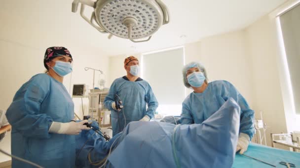 Le bloc opératoire. Une équipe de médecins qui opère un patient allongé sur la table d'opération. Groupe de chirurgiens en uniforme médical en salle d'opération. Personnel médical. Concept chirurgical. — Video