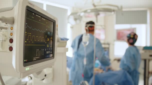 Σύγχρονη ιατρική χειρουργική αίθουσα με οθόνη. Γραφικές γραμμές στην οθόνη της οθόνης για να δείξει καρδιά ecg για την κατάσταση των ασθενών κατά τη διάρκεια της επέμβασης. Καρδιακός παλμός στο θέατρο του νοσοκομείου. — Αρχείο Βίντεο