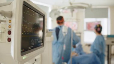 Hastane ameliyathanesinde kalp monitörü. Ameliyat sırasında hastane tiyatrosunda kalp atışı ve hasta kontrol monitörü. Tıbbi Ekip Modern Ameliyat Odasında Cerrahi Operasyon Yapıyor