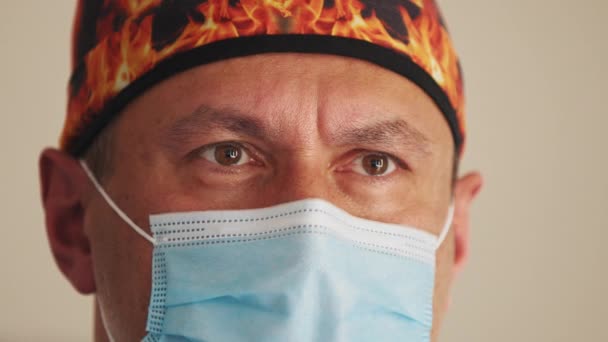 Hombre profesional de la salud en un quirófano del hospital con gorra quirúrgica y máscara. Retrato de un médico o cirujano que se ve orgulloso de su habitación, feliz y sonriente por su trabajo en la clínica. — Vídeos de Stock