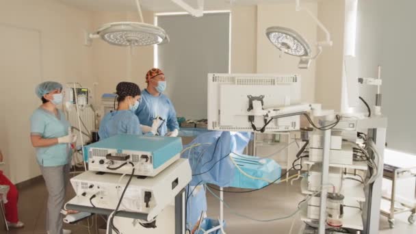 De operatie werd geleid door professor en assistent. Endoscopische transnasale chirurgie. Artsen en een verpleegkundige kijken naar endoscoop monitor tijdens chirurgische ingreep. — Stockvideo