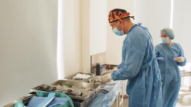 Sala de operaciones de mesa quirúrgica con instrumentos, el médico recoge instrumentos para cirujanos durante la operación. Cirugía en progreso. Médicos profesionales realizando cirugía. — Vídeo de stock