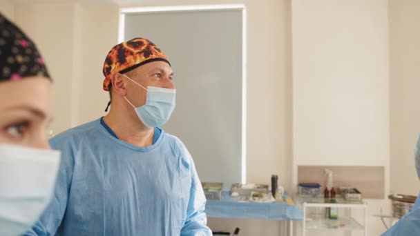 患者を保存と生活モニターを見て手術の劇場での仕事で 3 つの外科医。蘇生医学チームは患者を保存保護マスクを着用します。手術や緊急のコンセプト — ストック動画