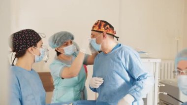 Ameliyathanede ameliyat sırasında hemşire ya da asistan maskeyi yorgun bir doktora takar. Konsantre cerrahi ekibi ameliyathanede bir hastayı ameliyat ediyor. Cerrahi Ekibi