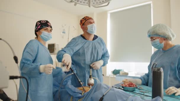 Proces gynekologického chirurgického zákroku za použití laparoskopického vybavení. Skupina chirurgů na operačním sále s chirurgickým vybavením. Zdobit portrét sester v ochranných maskách a sterilních rukavicích — Stock video