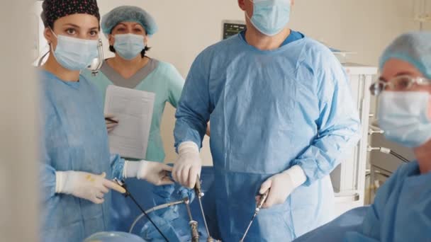 Cirujano masculino que preforma la operación extirpación del útero en el quirófano del hospital, cirujano hombre que opera paciente que trabaja con instrumentos de laparoscopia quirúrgica. Ginecología. — Vídeo de stock