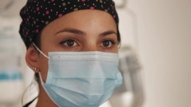 Doktor ya da yüz maskeli hemşire, cerrahi müdahale kliniğini kapatın. Hastanede iç mekanda tıbbi maske takan güzel bir kadın doktorun portresi. Tıp konsepti.