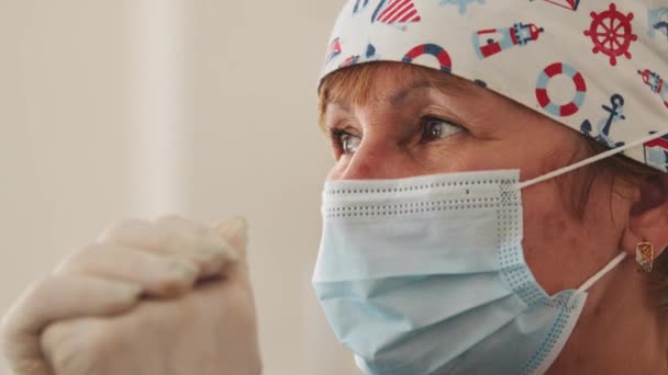 Femme âgée médecin en masque médical. Portrait d'une femme médecin âgée confiante à l'hôpital ou à la clinique. Médecin femme plus âgée portant un masque facial — Video