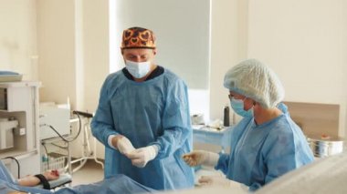 Cerrah ameliyattan sonra bornozu çıkarıp atıyor. Erkek cerrah ameliyattan sonra eldiven ve önlüğü çıkarır. Cerrah hastanede başarılı bir ameliyattan sonra soyunur..