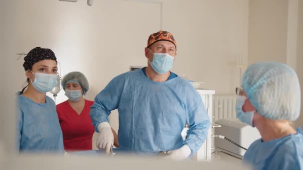 Cirujano del equipo en el quirófano. Equipamiento moderno en quirófano. Dispositivos médicos para neurocirugía. Equipo médico que realiza la operación quirúrgica en la sala de operaciones moderna brillante — Vídeo de stock