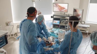 Laparoskopik ekipman kullanarak operasyon. Laparoskopik ekipman kullanılarak yapılan jinekolojik ameliyat. Ameliyathanede ameliyat ekipmanlarıyla bir grup cerrah..