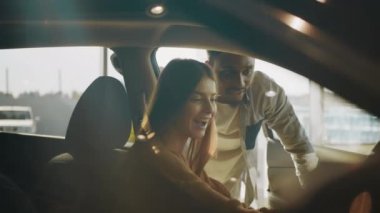 Afrikalı satıcı, galeride yeni araba seçen beyaz kadın için profesyonel danışmanlık sağlıyor. İnsanlar ve otomobil işi kavramı. Satıcı, kadının galeride yeni araba seçmesine yardım ediyor.