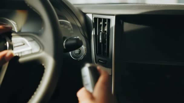 Motoren starten. Ga naar de knop. Vinger druk op de knop om de motor te starten. Close-up van de man met contactloze autosleutel in de hand en opwinding dure auto knop — Stockvideo