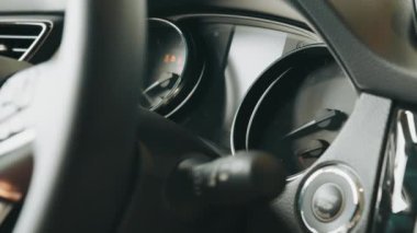 Araba motorunu çalıştırıyorum. Düğmeye kadar takip et. Parmak, motoru çalıştırmak için düğmeye bas. Gösterge paneli arabada. Hız göstergesi ve hareketli, ışık sızıntısı var. Sürüşe hazırlanılıyor.