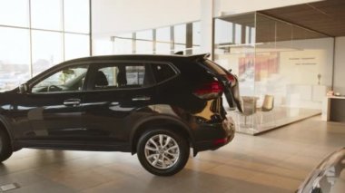 Galerideki otomatik bagaj açılışındaki araba. Otomatik kaldırma işlemini gösteriyor. Arabanın yeni fonksiyonu. Teknoloji ve ulaşım kavramları.