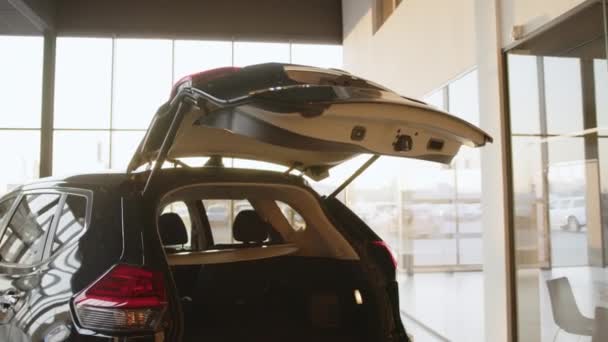 La voiture dans l'ouverture automatique du coffre du showroom. Démonstration de l'ascenseur automatique. Nouvelle fonction de la voiture. Technologies et concepts de transport. — Video