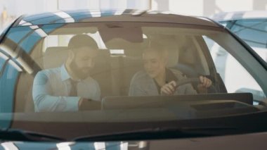Çekici bir çift test sürüşünden önce modern elektrikli araç seçiyor ve inceliyor. Otomatik trendler ve yenilikler. Eko araba satışı konsepti. Otomatik sürüş sistemi olan elektrikli aracın test sürüşü.