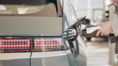 Elektrikli bir hibrit arabanın şarj prizinin bağlantısını kes. Elektrikli bir arabanın yakıt doldurma işlemi tamamlandı. Kapak otomatik olarak kapanır. Carr yüklendikten sonra kabloyu kes