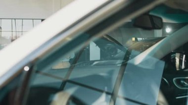 Araba galerisinde araba almak isteyen sarışın, kısa saçlı, iş kadını bir kadınla dolaşan ve araba özellikleri hakkında konuşan ciddi bir erkek araba satıcısı. İnsan ve ulaşım kavramı.