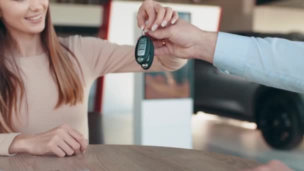 Salesman handing keys to a woman after buying a car. Showroom Dealer The Gives Car Keys To The Buyer. Dialogue With A Dealer. Cheerful Customer. Automobile Salon. Make A Decision. End Of A Deal. — Vídeos de Stock