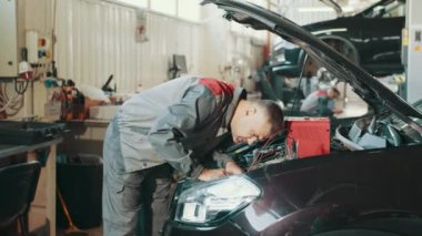 Makinistin müşteriye bakımı ve incelemesi. Araç kaputu, güvenlik denetim motoru, ulaşım onarım servisi. Otomatik servis, onarım, bakım kavramı.