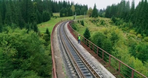 En flygplansfotograf på järnvägen. Ingenjör arbetar med järnväg. Ingenjör promenader och kolla spår arbete på järnvägar. Folk går på järnväg. Ingenjörsarbete på järnväg — Stockvideo