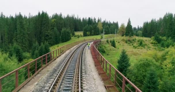 Bouw van luchtfoto 's op spoorwegen. Werkzaamheden van ingenieurs op het spoor. Mensen lopen op het spoor. Ingenieur spoorweginspectie. Bouwvakker op spoorwegen. Werkzaamheden van ingenieurs op spoorweggebied — Stockvideo