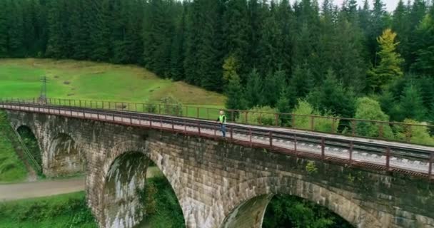 Letecký dělník na železnici. Portrétní inženýr v procesu kontroly a kontroly stavebních výhybek. Inženýr v pracovní uniformě a bezpečnostní přilbě. — Stock video