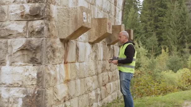 Senior male engineer to restore ancient buildings or bridges. Reconstruction of bridges, preservation of ancient railway bridges. Engineer-inspector at work. Inspect and checking concept — ストック動画