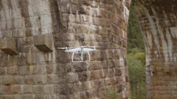 Drone sotto un ponte che fa un'ispezione. Ispezione del vecchio ponte con drone. Ispettori di sicurezza che lavorano in altezza su un ponte del veicolo che ispeziona il calcestruzzo alla ricerca di crepe e danni — Video Stock