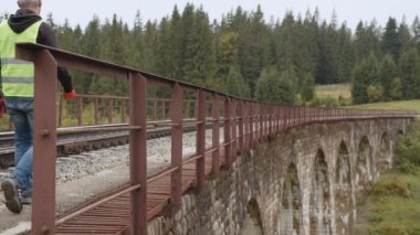 Demiryolu mühendisi demiryolu hattını kontrol ediyor. Demiryolu raylarının denetimi ve kontrolü mühendis tarafından gerçekleştirilir ve tüm sapmalar ulaşımın güvenliği için sabitlenir