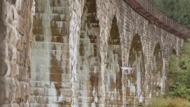 Drone sotto un ponte che fa un'ispezione. Ispezione del vecchio ponte con drone. Ispettori di sicurezza che lavorano in altezza su un ponte del veicolo che ispeziona il calcestruzzo alla ricerca di crepe e danni — Video Stock