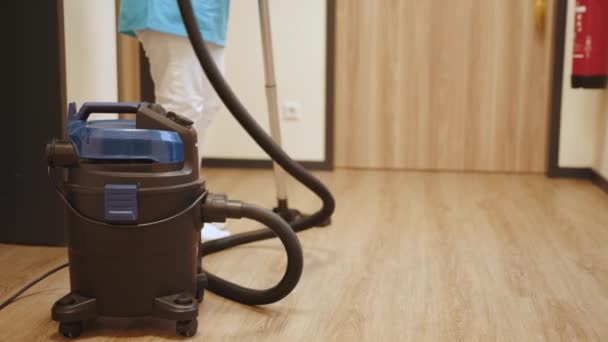 Worker cleaning carpet using professional-grade equipment. Vacuuming the light oak floor with water. Wet cleaning of housing. Technologies that facilitate cleaning. Modern household appliances — Stok video