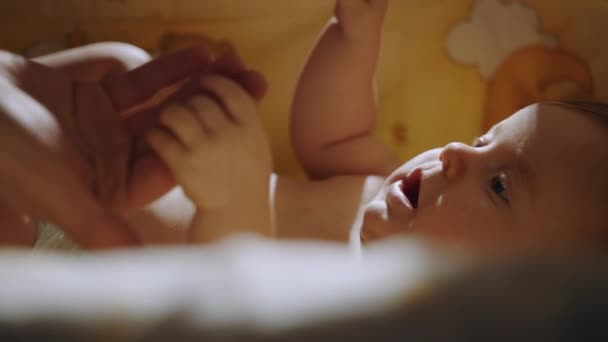 Close-up shot of babys little hand reaching for fathers loving finger. Baby holding parents finger. Parent holding newborns hand in Slow Motion. Hand in hand. Father or mother and newborn baby . — Stockvideo