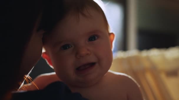 Happy Mother Holding Cute Newborn Baby in Cozy Dark Kids Bedroom in the Evening. Caring Mom Hugging the Neonate Toddler and They are Bonding Before Sleep. Concept of Childhood, New Life, Parenthood. — Stock Video