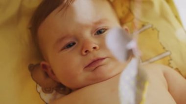 Çocuk Beşiğinde Arkasında Yatan Sevimli Yeni Doğan Bebeğin Otantik Yakın Çekimi. Heyecanlı bir yenidoğan çocuğun Dönen Oyuncaklara Bakışlı Portresi. Çocukluk kavramı, Yeni Hayat.