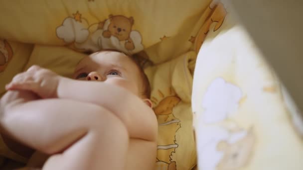 Aranyos baba fekszik a bölcsőjében. Gyönyörű közeli felvétel — Stock videók