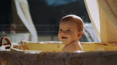 Akşamları beşikte oturacak bebek, gece lambası ışığında mutlu bebeğin yüzü. Yeni doğmuş güzel bir bebek. Yeni doğmuş şirin bir bebek beşiğinde oturuyor. Çocukluk kavramı. Uykusuz gece.