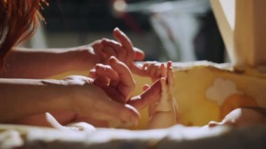 Close Up Footage of Newborn Baby Playing With Mothers Hand. Mom holds the hand of a newborn. close-up baby hand. hospital caring happy family medicine concept. baby newborn holding mom hand close-up
