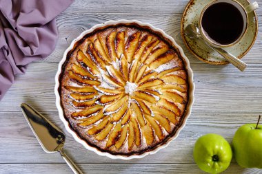 Elma kokulu beyaz seramik bir turta eski ahşap bir masada bir fincan sade kahveyle pişirmek için. Lezzetli ve sağlıklı yemekler..