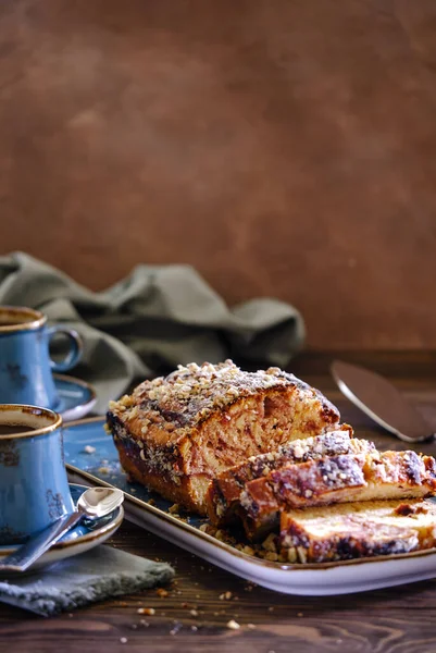 Tahta bir masada mavi bir tabakta limonlu ve çilekli ev yapımı kek. Koyu sıcak kahveyle nefis kahvaltı.