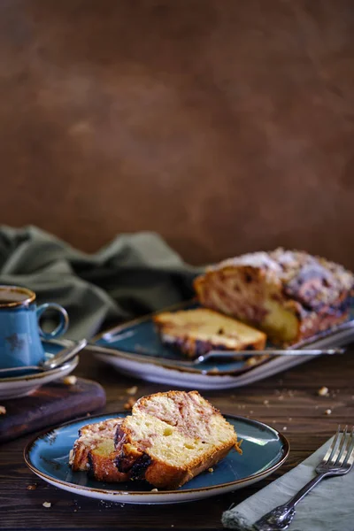 Tahta bir masada mavi bir tabakta limonlu ve çilekli ev yapımı kek. Koyu sıcak kahveyle nefis kahvaltı.
