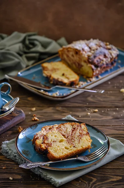 Tahta bir masada mavi bir tabakta limonlu ve çilekli ev yapımı kek. Koyu sıcak kahveyle nefis kahvaltı.