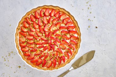 Beyaz ahşap arka planda lezzetli çilekli tart.